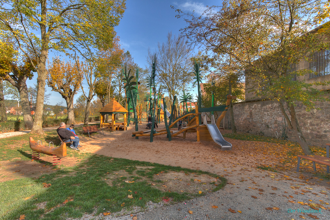 Freizeitanlage Försterallee. Ausser dem Kinderspielplatz beinhaltet sie einen Fitnessbereich für Erwachsene, einen Ruhebereich mit Liegen zum Sonnen, einen Biergarten für die Eltern sowie ein Sportfeld und einen Wasserspielplatz